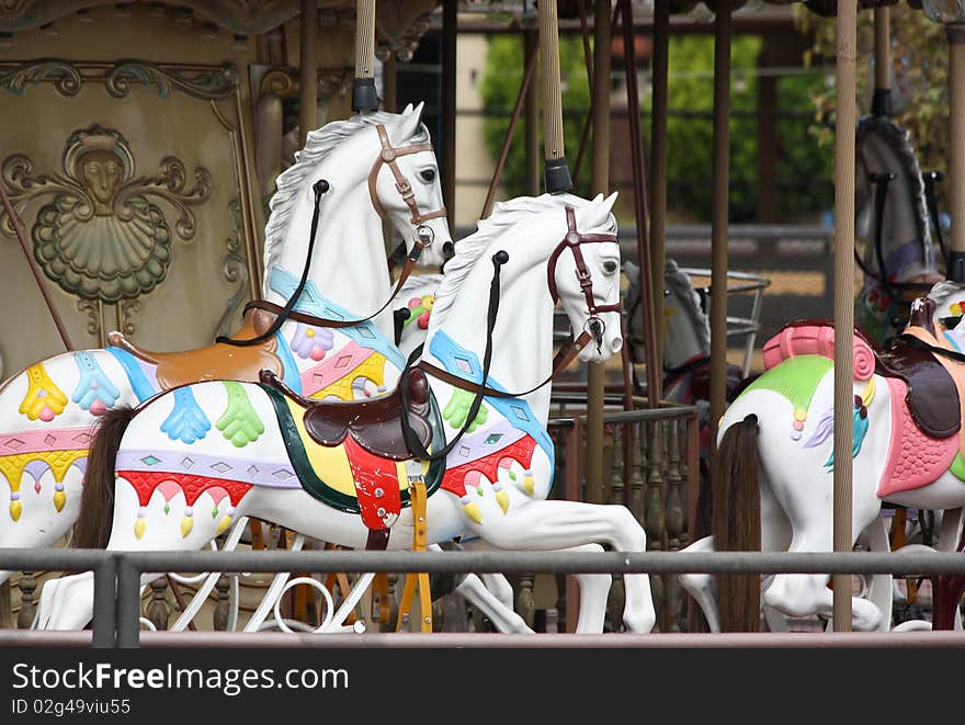 White toy horses on a merry-go-round. White toy horses on a merry-go-round.