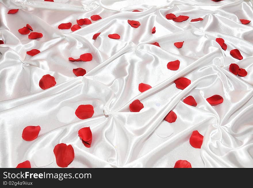 Red roses petals on white silk. Red roses petals on white silk.