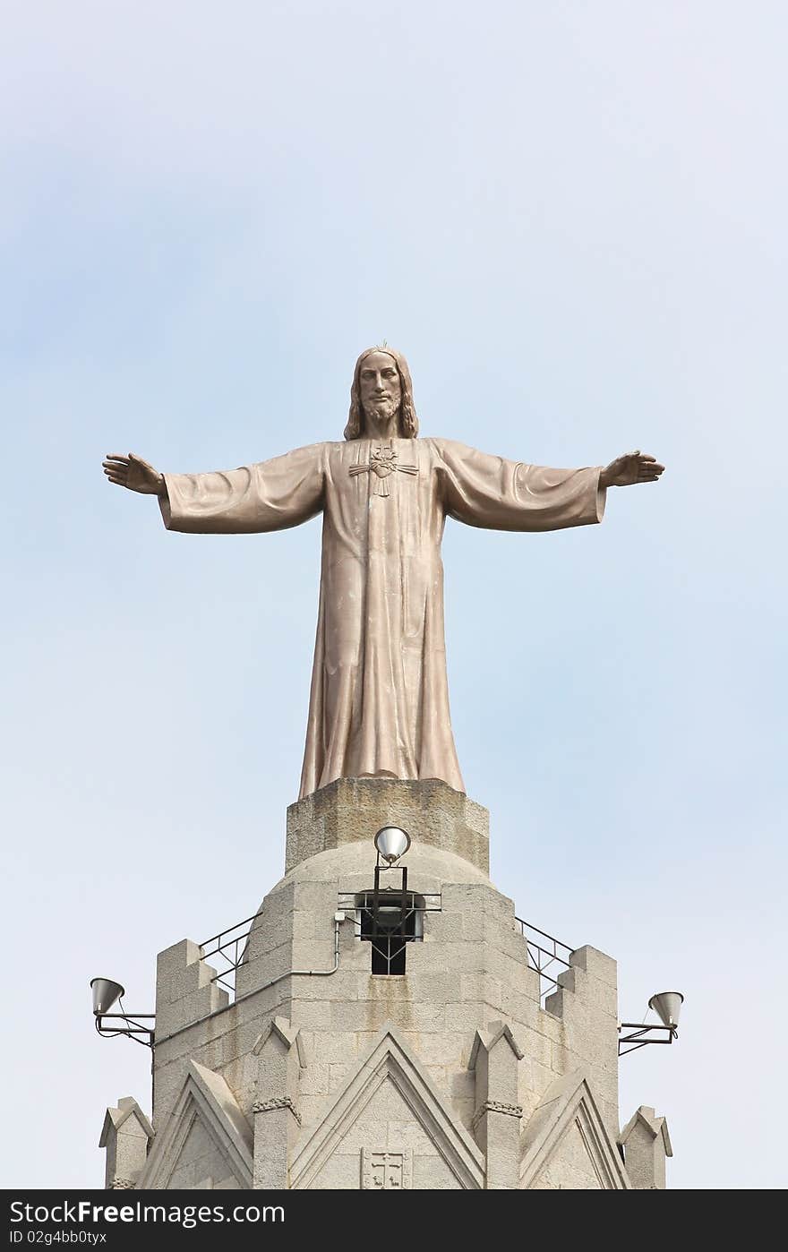 A huge bronze statue of Jesus Christ located on the top of Sagrat Cor temple (Tibidabo mountain, Barcelona). A huge bronze statue of Jesus Christ located on the top of Sagrat Cor temple (Tibidabo mountain, Barcelona).