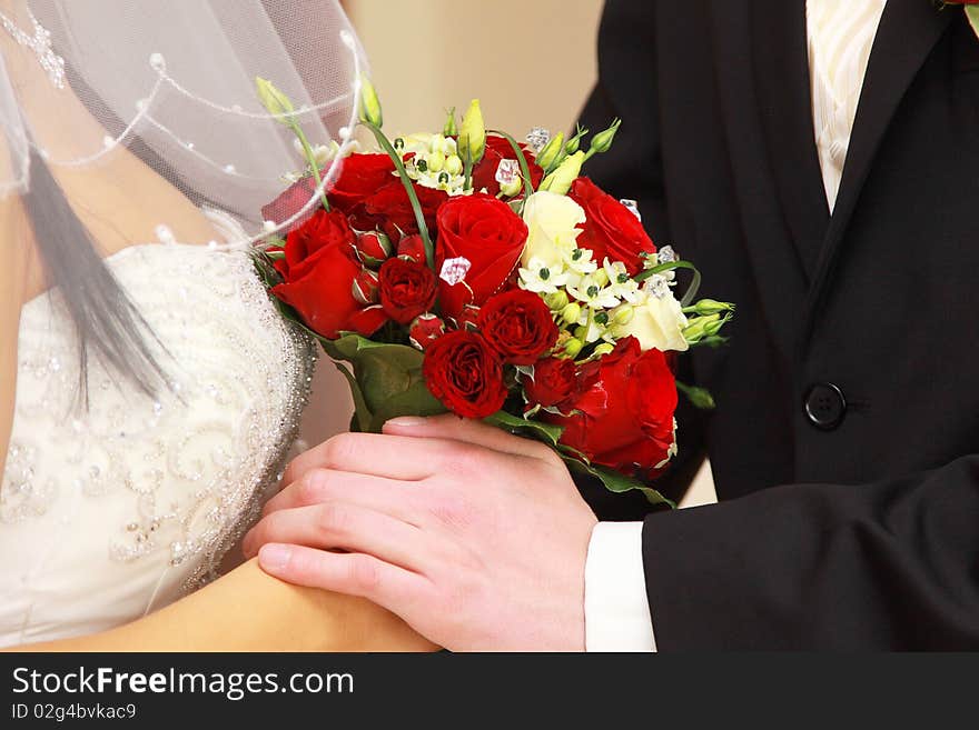 Bride and groom with red rose bouquet holding hands. Bride and groom with red rose bouquet holding hands.