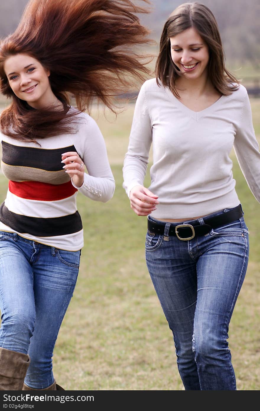 Two cheerful walking girls in the park. Two cheerful walking girls in the park