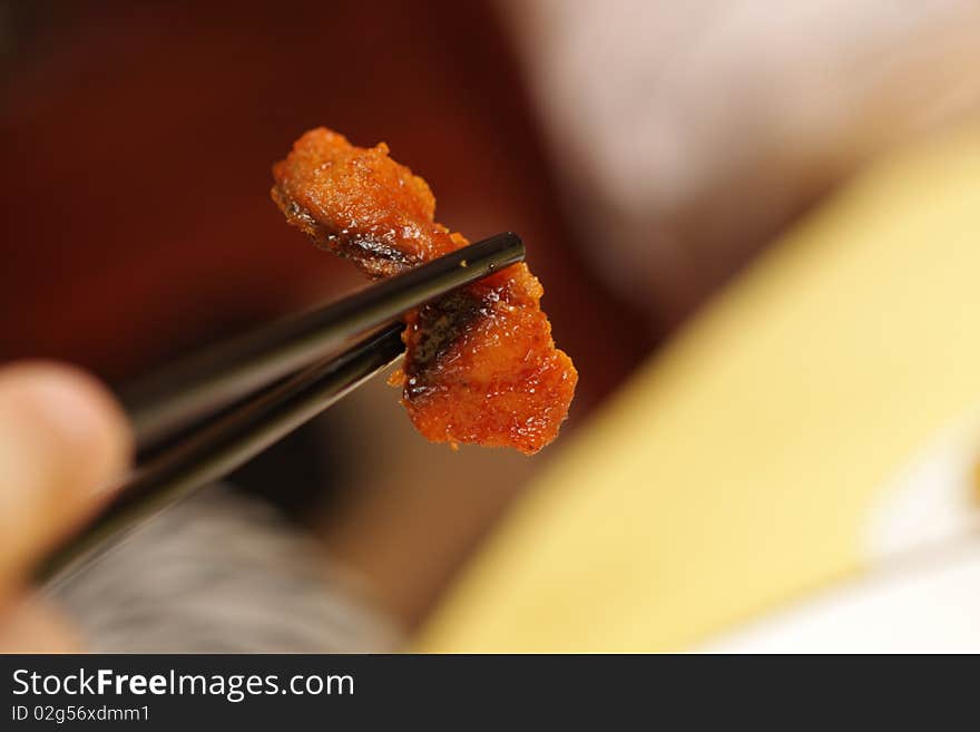 A man holding meat by chopsticks at chinese restaurant, Beijing. A man holding meat by chopsticks at chinese restaurant, Beijing