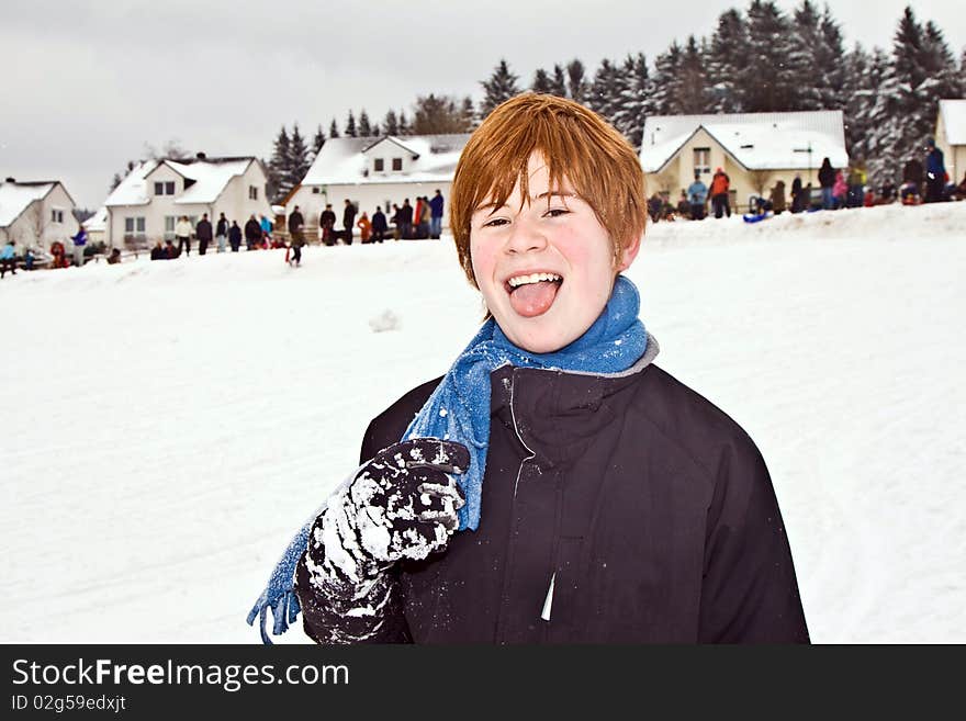 Boy with red hair looks happy from playing in the snow and having a snowball fight. Boy with red hair looks happy from playing in the snow and having a snowball fight