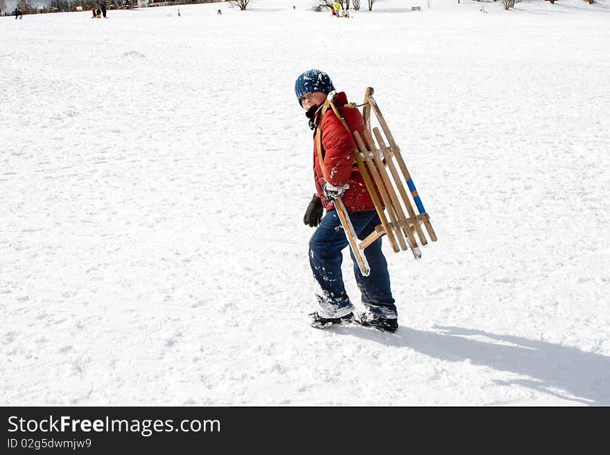 Young Boy Carries The Sledge