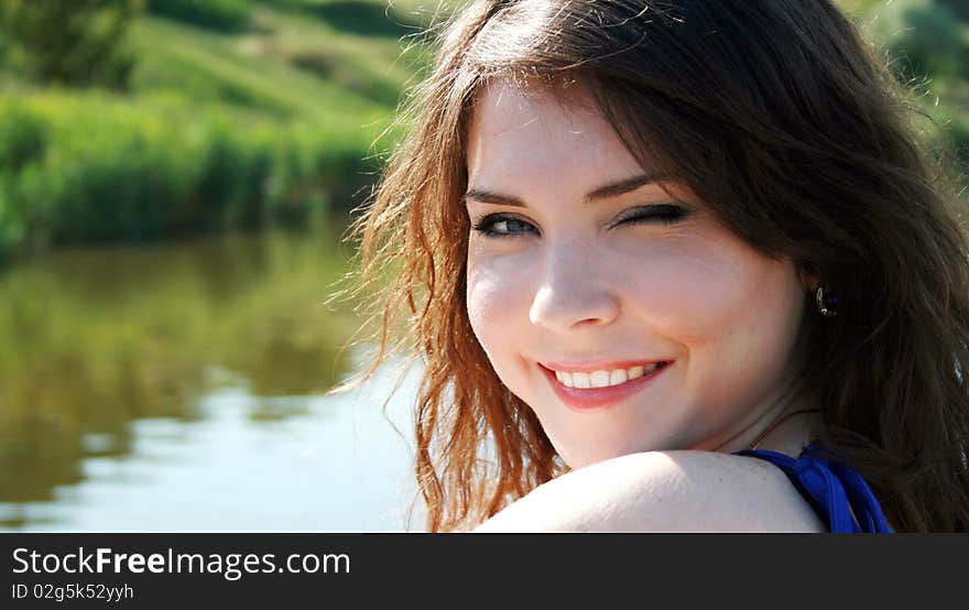 Pretty smiling woman portrait near the river