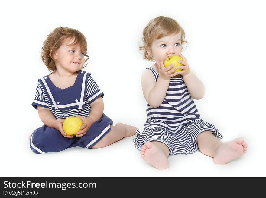 Two toddler girls with green apples over white