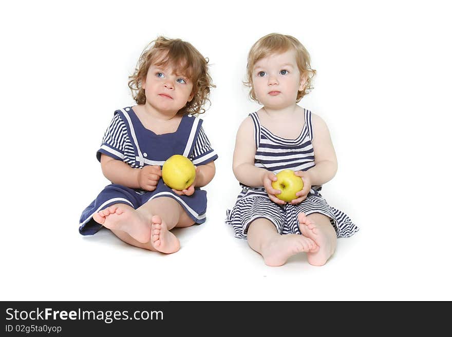 Two toddler girls with green apples over white