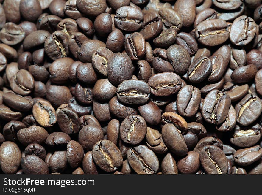 The fragrant fried grains of coffee spread out on a table