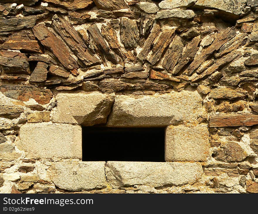 Small little window in the old stone wall