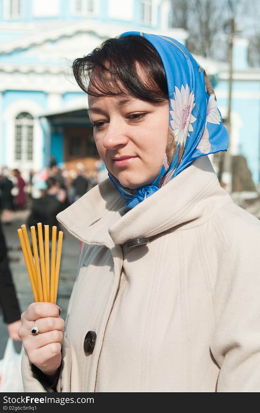 Young beautiful woman with tapers in hand and shawl on head