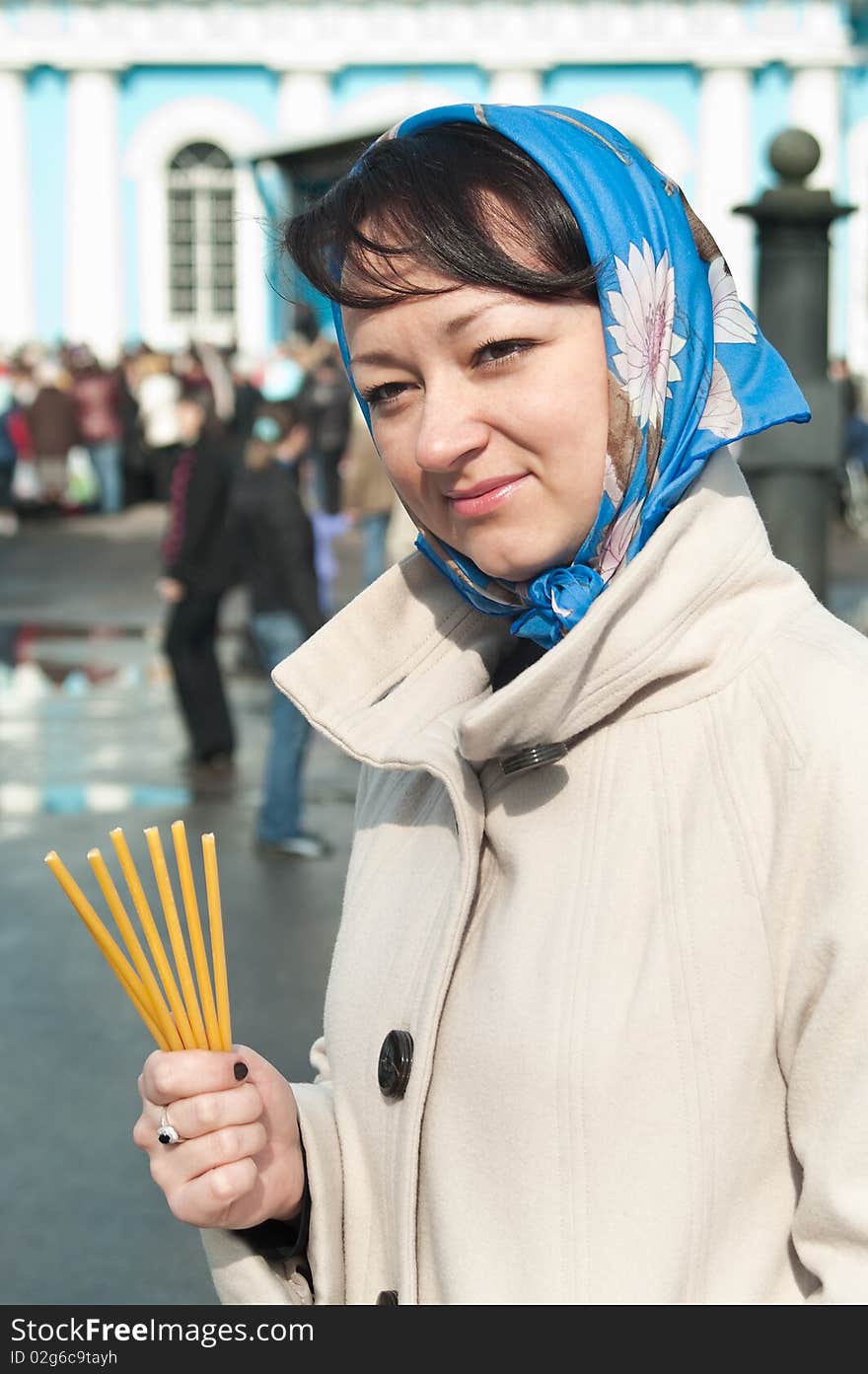 Young beautiful woman with tapers in hand and shawl on head