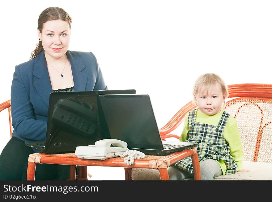 The small child and young mother together work on laptops, sitting at a table. It is isolated on a white background. The small child and young mother together work on laptops, sitting at a table. It is isolated on a white background