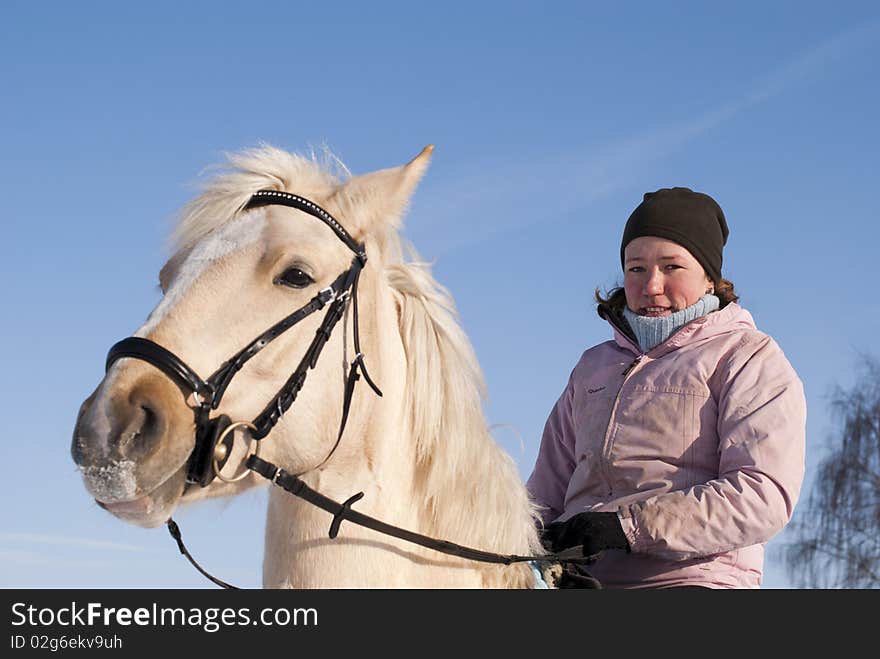 Young girl looking at camera on horseback of the white horse. Young girl looking at camera on horseback of the white horse