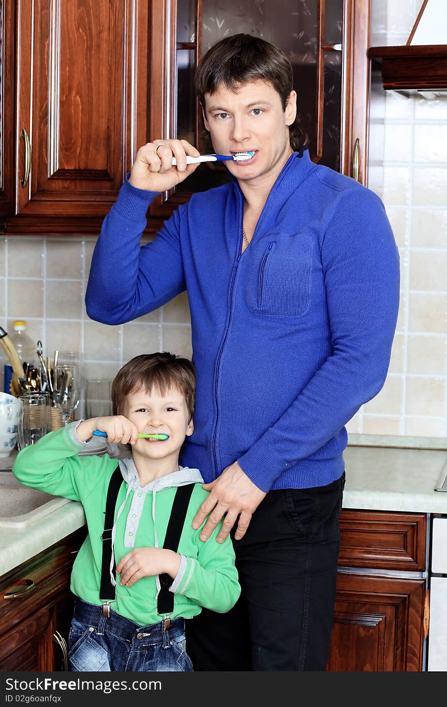 Happy father with his son brushing their teeth at home. Happy father with his son brushing their teeth at home.