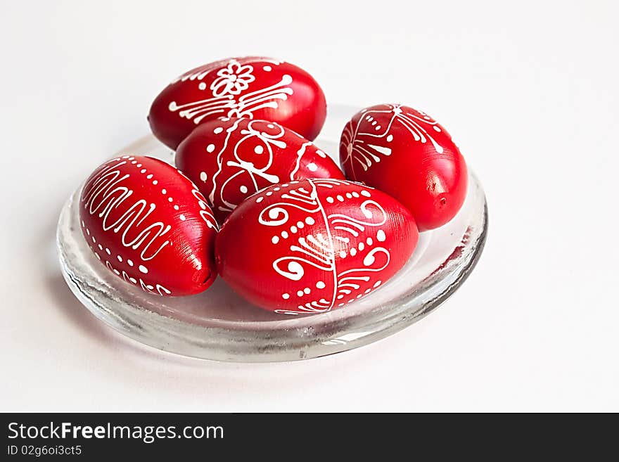 Red Easter eggs on a glass plate on white background. Red Easter eggs on a glass plate on white background