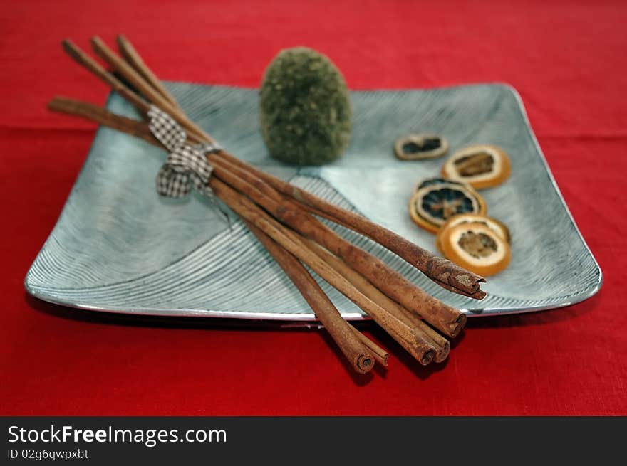 Cinnamon bark on plate in red background