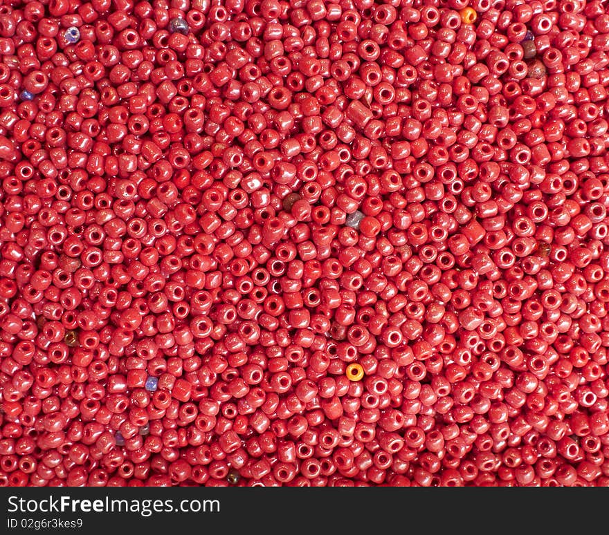 Colorful fake beads, ruby red background