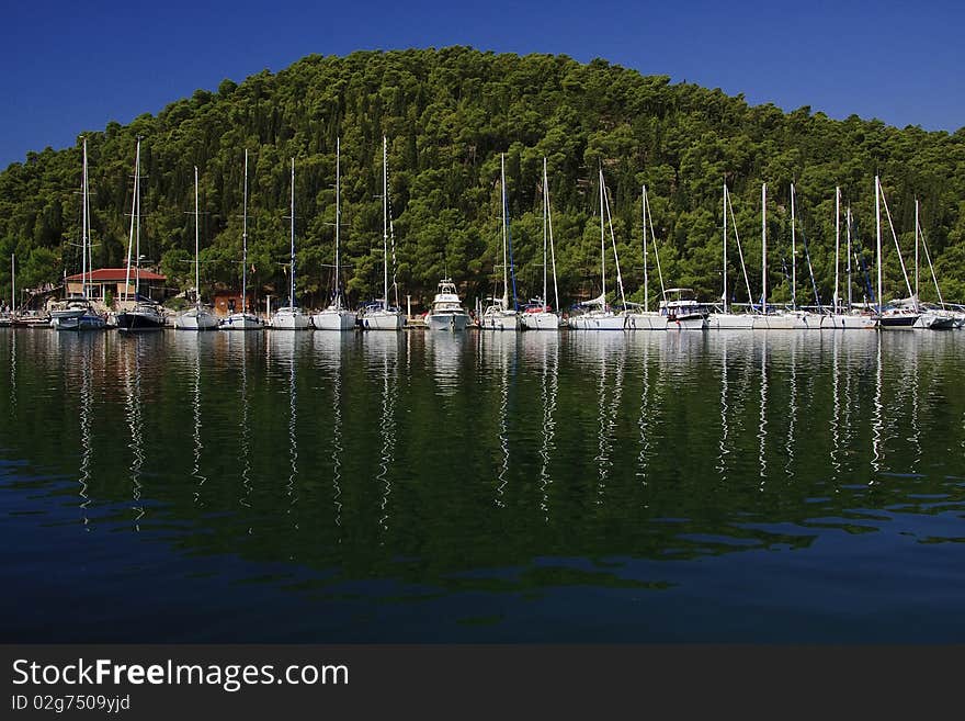 Yachts reflecting on the water surface. Yachts reflecting on the water surface