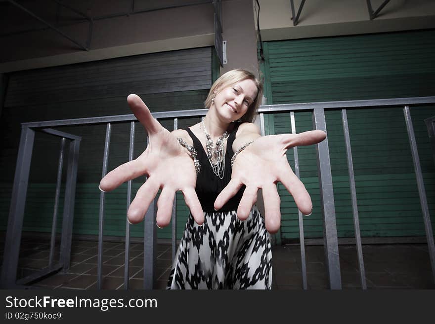 Attractive young woman reaching out her hands towards the camera and smiling