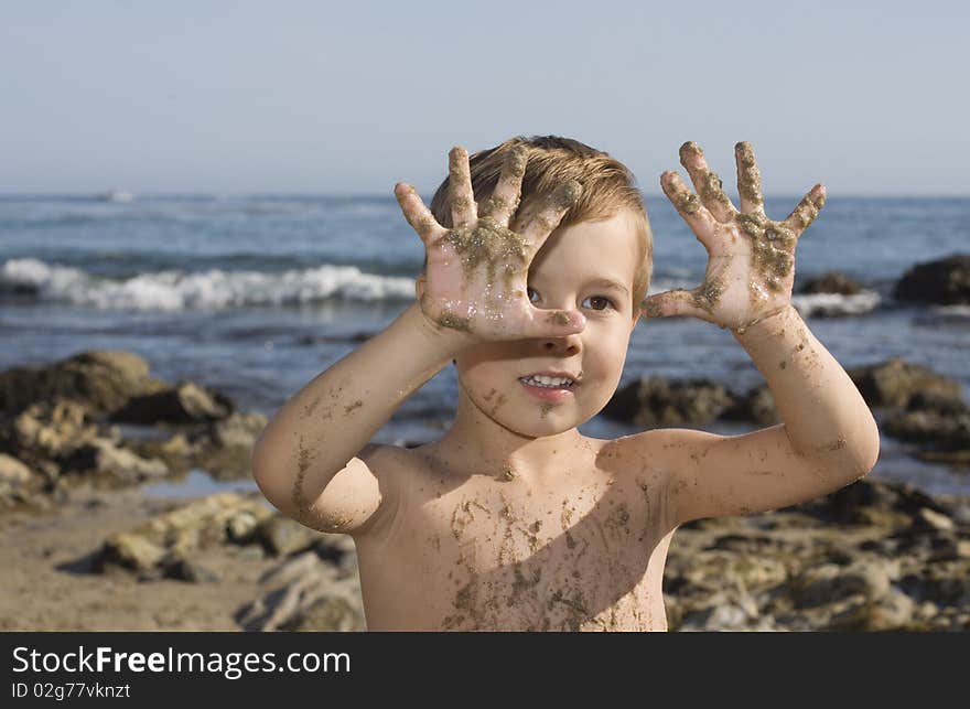 Boy at the beach playing with sand