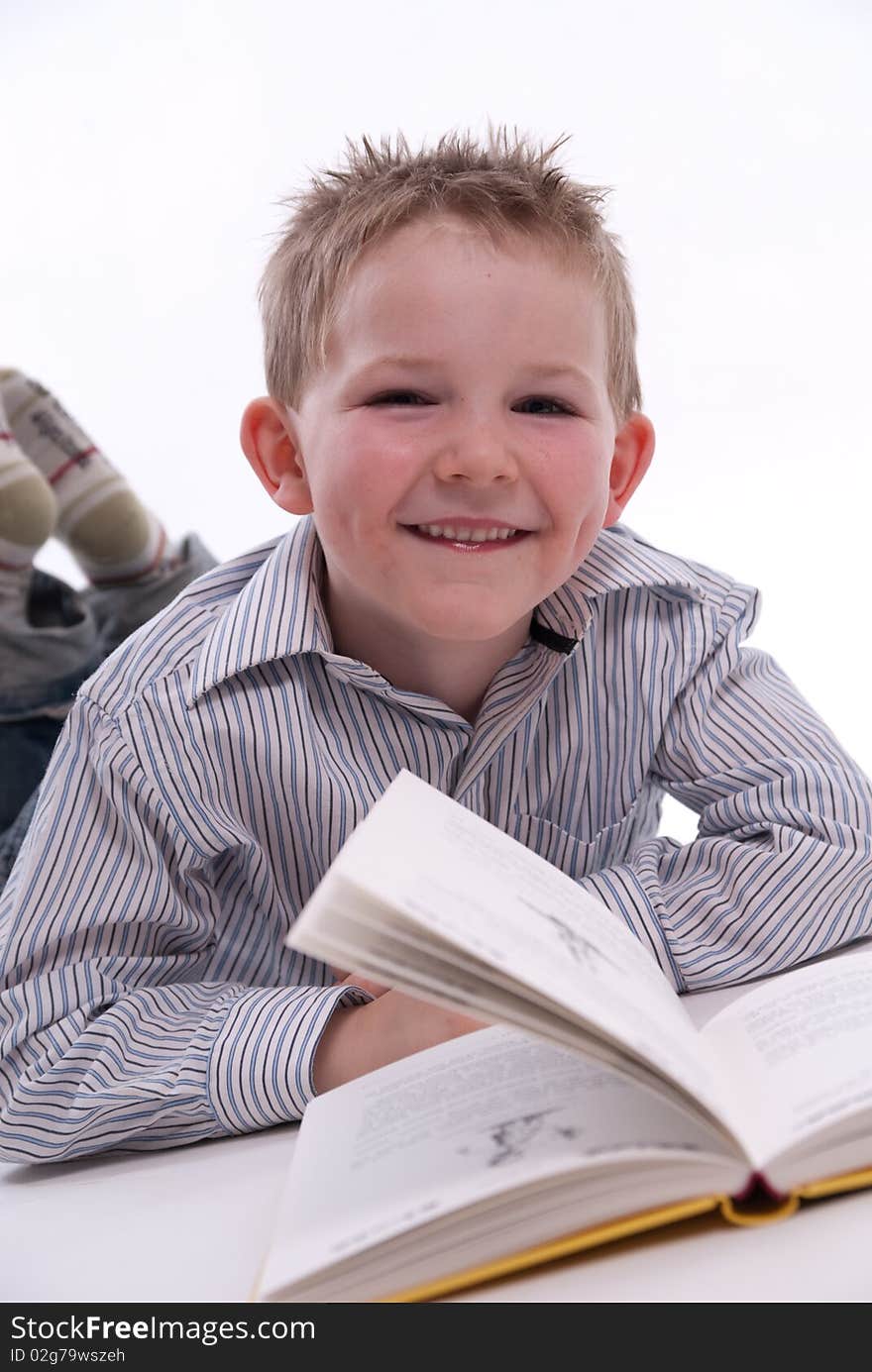 A boy has fun while he reads a book. A boy has fun while he reads a book