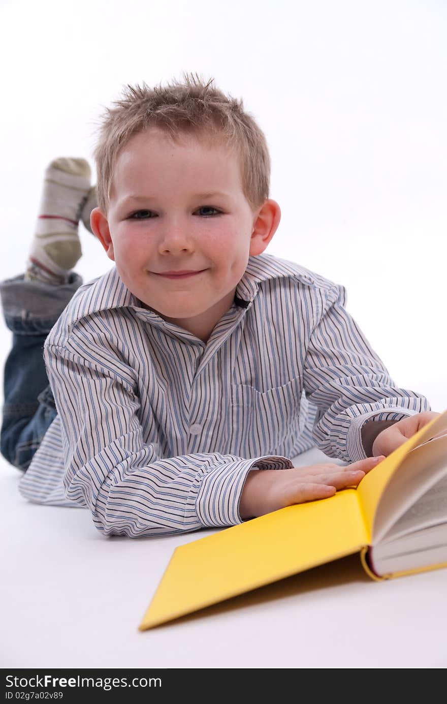 A boy has fun while he reads a book. A boy has fun while he reads a book