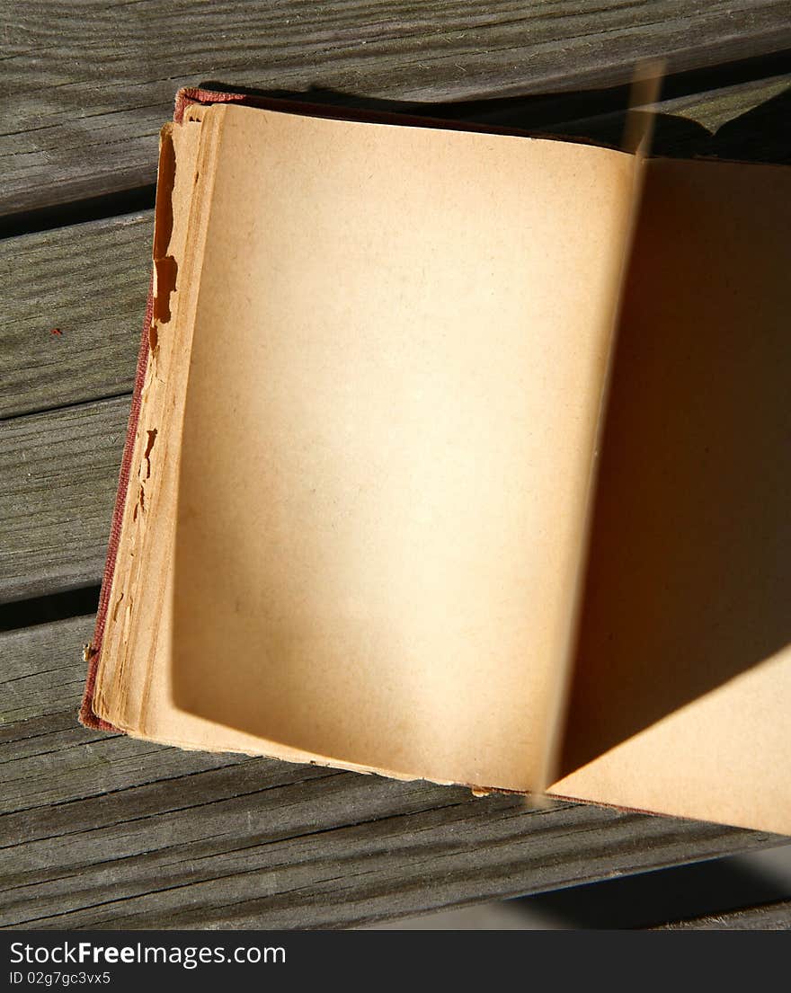 Blank pages of an old book turning on wooden background