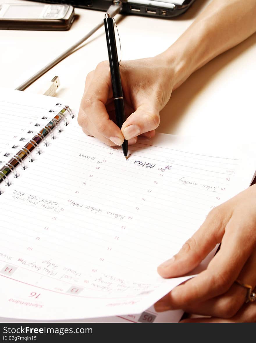 Business woman writing into notebook. Business woman writing into notebook