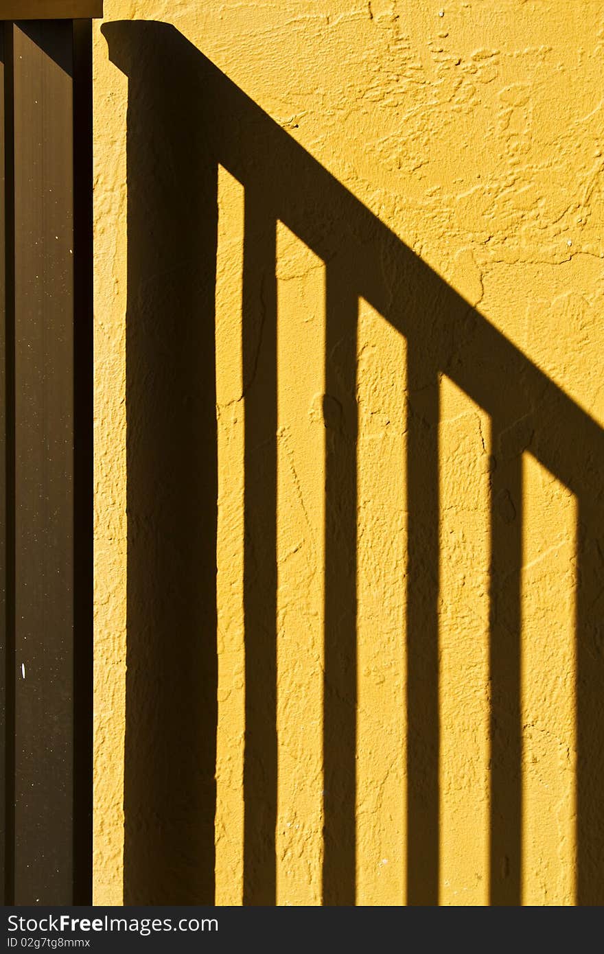 Shadow of hand rail on the yellow textured wall. Abstract. Shadow of hand rail on the yellow textured wall. Abstract.