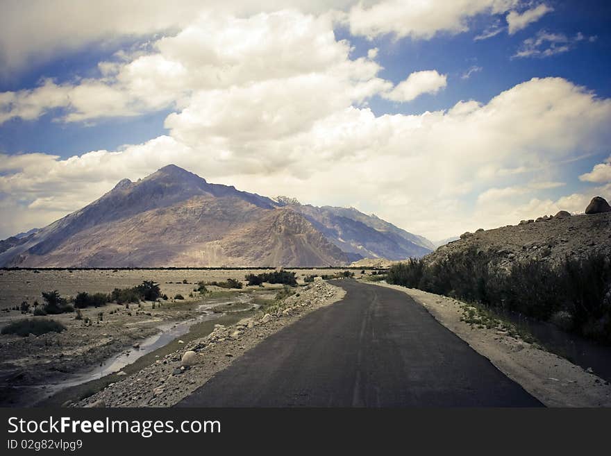 Road in Nubra valley, Ladakh, Kashmir. Mountain range and blue sky on background.