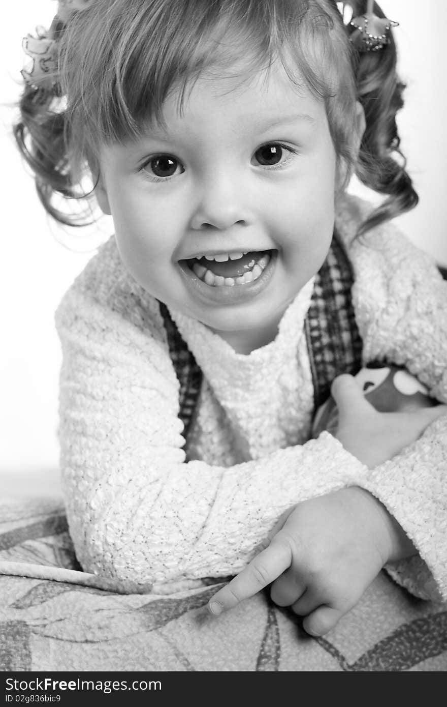 It is black a white portrait of the girl laying on a sofa. It is black a white portrait of the girl laying on a sofa