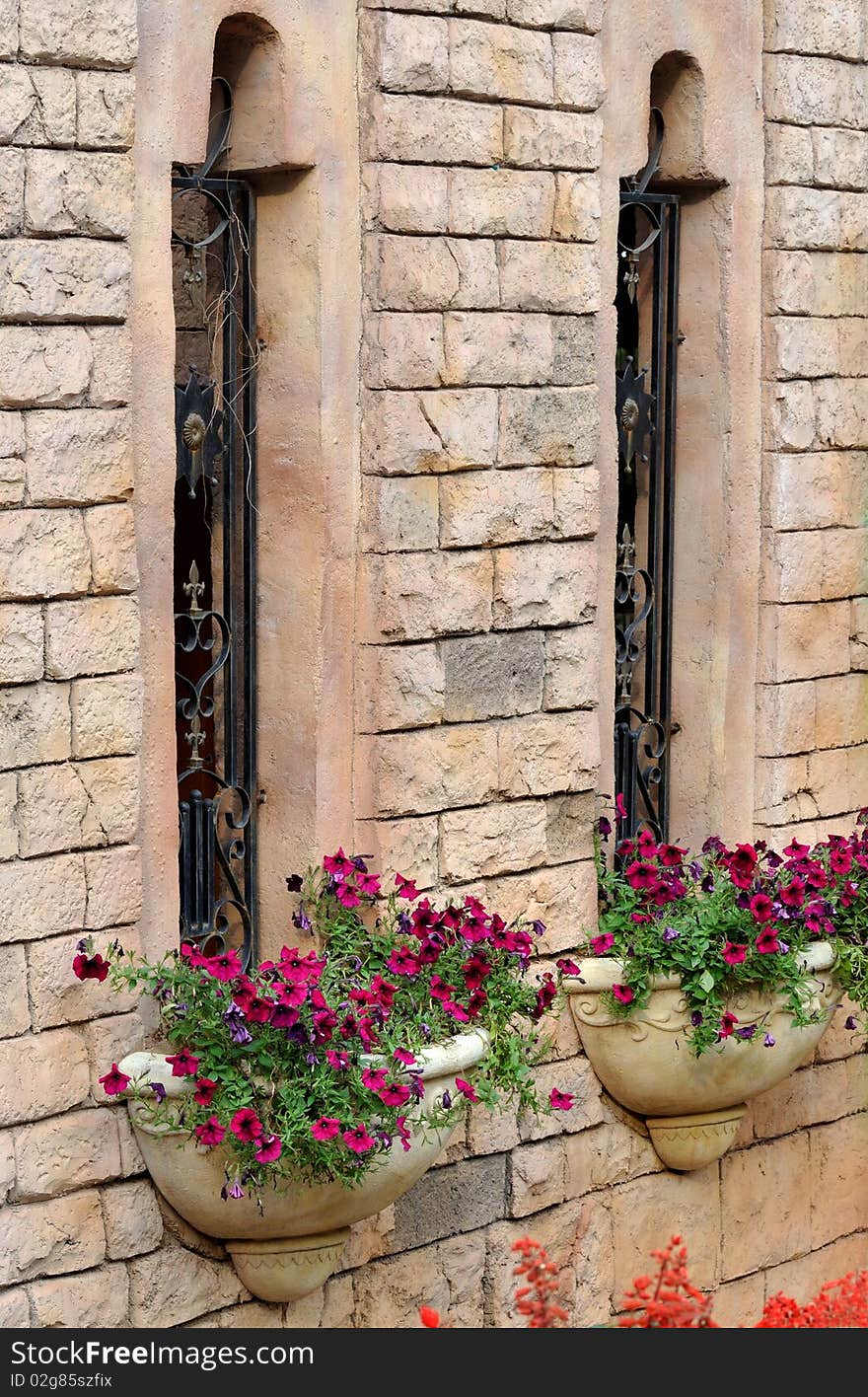 Two windows and small parterre or basket of flower, decorated on external wall of a castte building, with beautiful shape and harmonious color. Two windows and small parterre or basket of flower, decorated on external wall of a castte building, with beautiful shape and harmonious color.