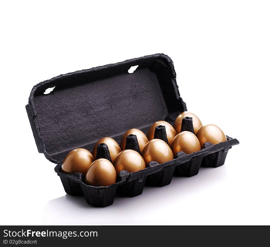 Gold eggs in a black carton on white background