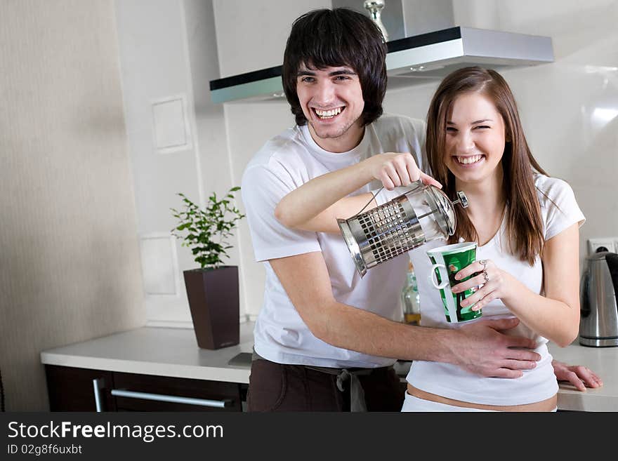 Boy with smile and beautiful girl with cup and with teapot. Boy with smile and beautiful girl with cup and with teapot