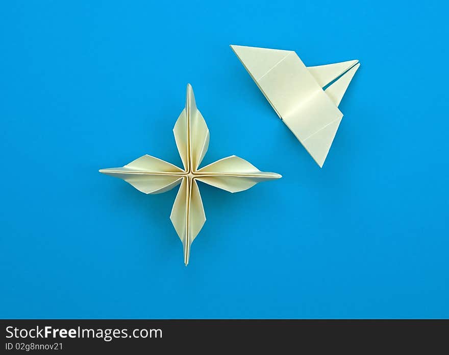 Origami flower with a butterfly on a blue background. Origami flower with a butterfly on a blue background