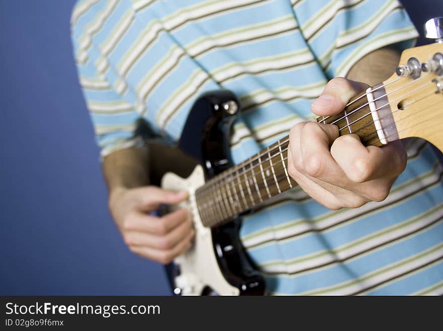 In the frame arms of the young guy, he plays electric guitar. In the frame arms of the young guy, he plays electric guitar