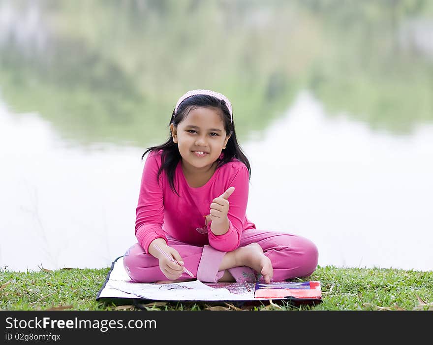 A girl is making schoolwork at the park. A girl is making schoolwork at the park