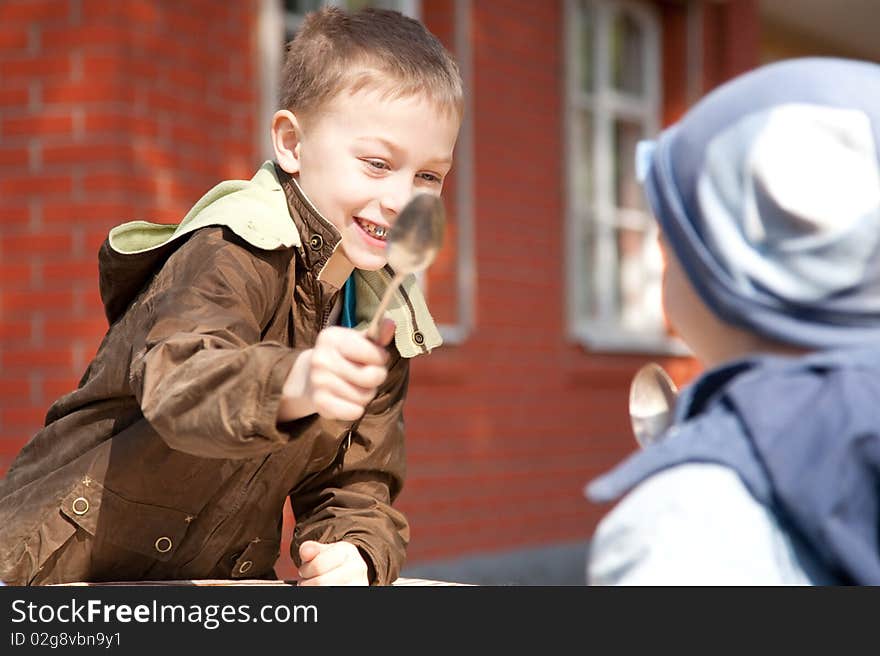 Two boys fighting with spoons