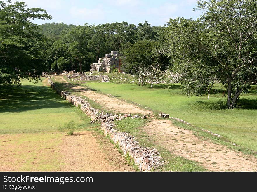 Mexican landscape with an old road running in the jungle with ruins af an ancient maya city. Mexican landscape with an old road running in the jungle with ruins af an ancient maya city