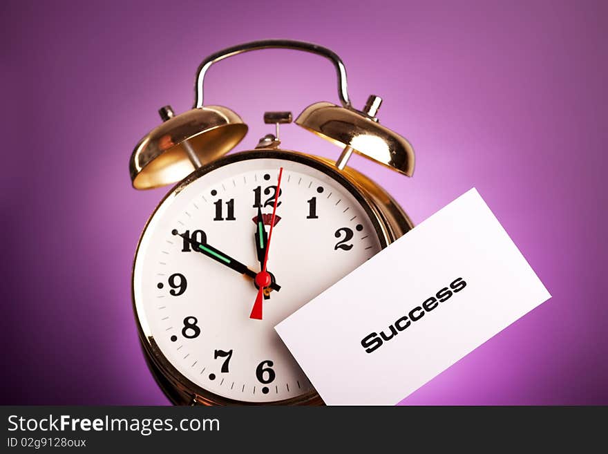 Clock with note shot in studio in violet background. Clock with note shot in studio in violet background