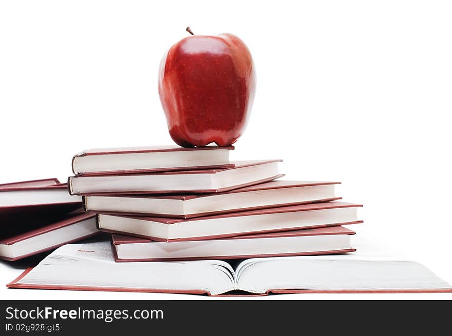 Stack of books and apple isolated over white