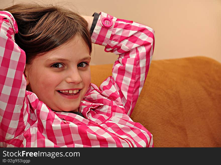 Portrait of young girl sitting on a sofa