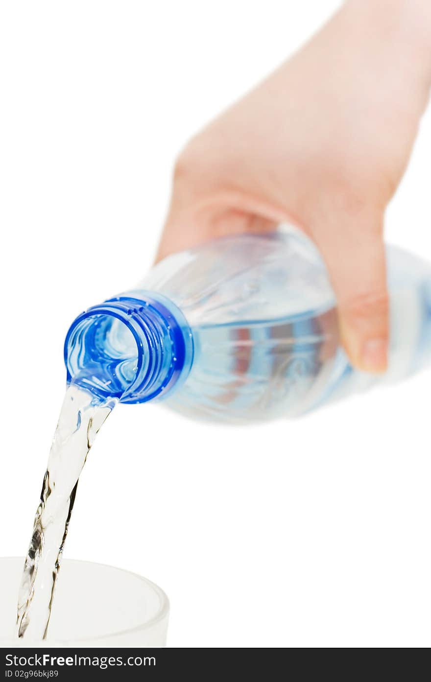 The girl pours water in a glass isolated over white