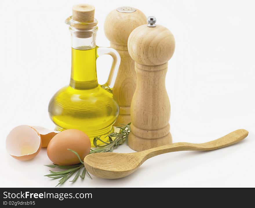 Olive oil, eggs, spices and a wooden spoon on a white background. Olive oil, eggs, spices and a wooden spoon on a white background