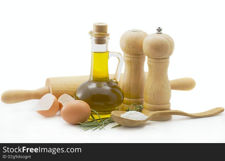 Olive oil, eggs, spices and a wooden spoon on a white background. Olive oil, eggs, spices and a wooden spoon on a white background