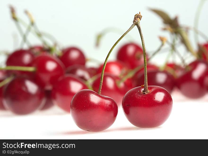 Two cherries on white background