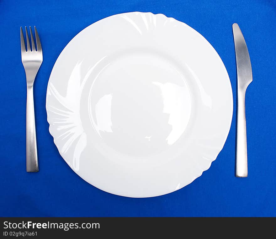 Table arrangement of fork and knife besides a plate. Table arrangement of fork and knife besides a plate