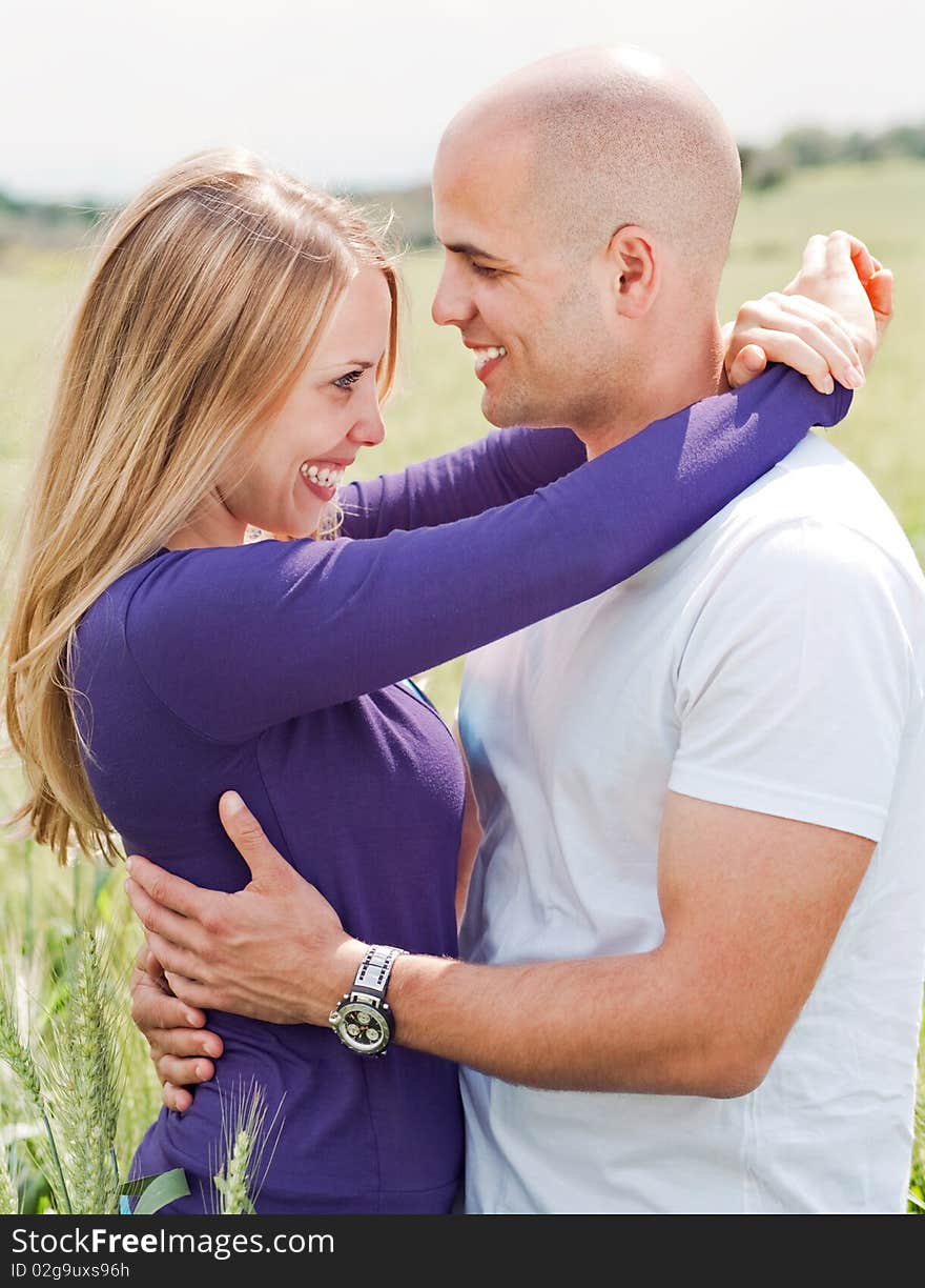 Men and woman hugging in the grass