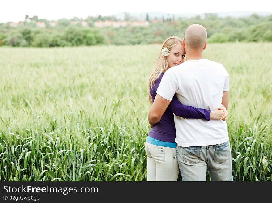 Lovers in park rear view, woman looking at camera in park