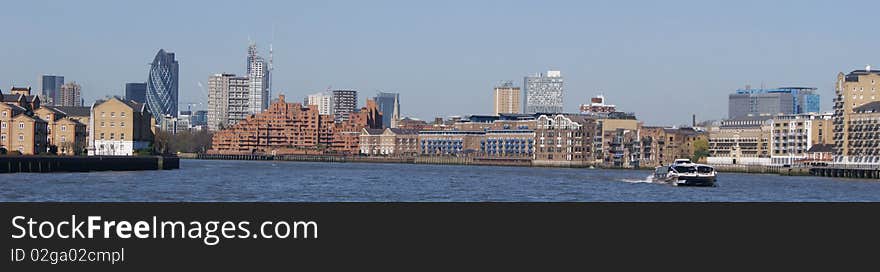 A boat on the thames with some of london's most famous buildings